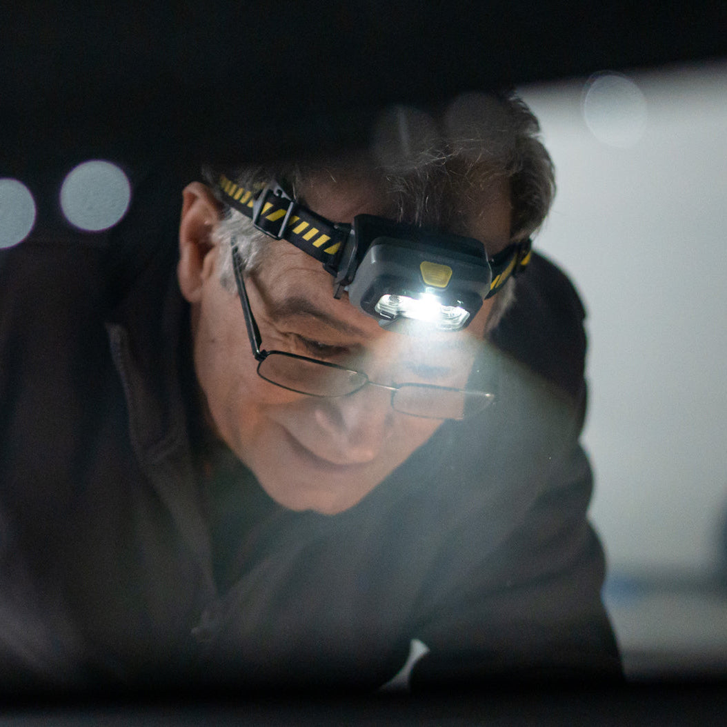 Person wearing a headlamp in a dark setting