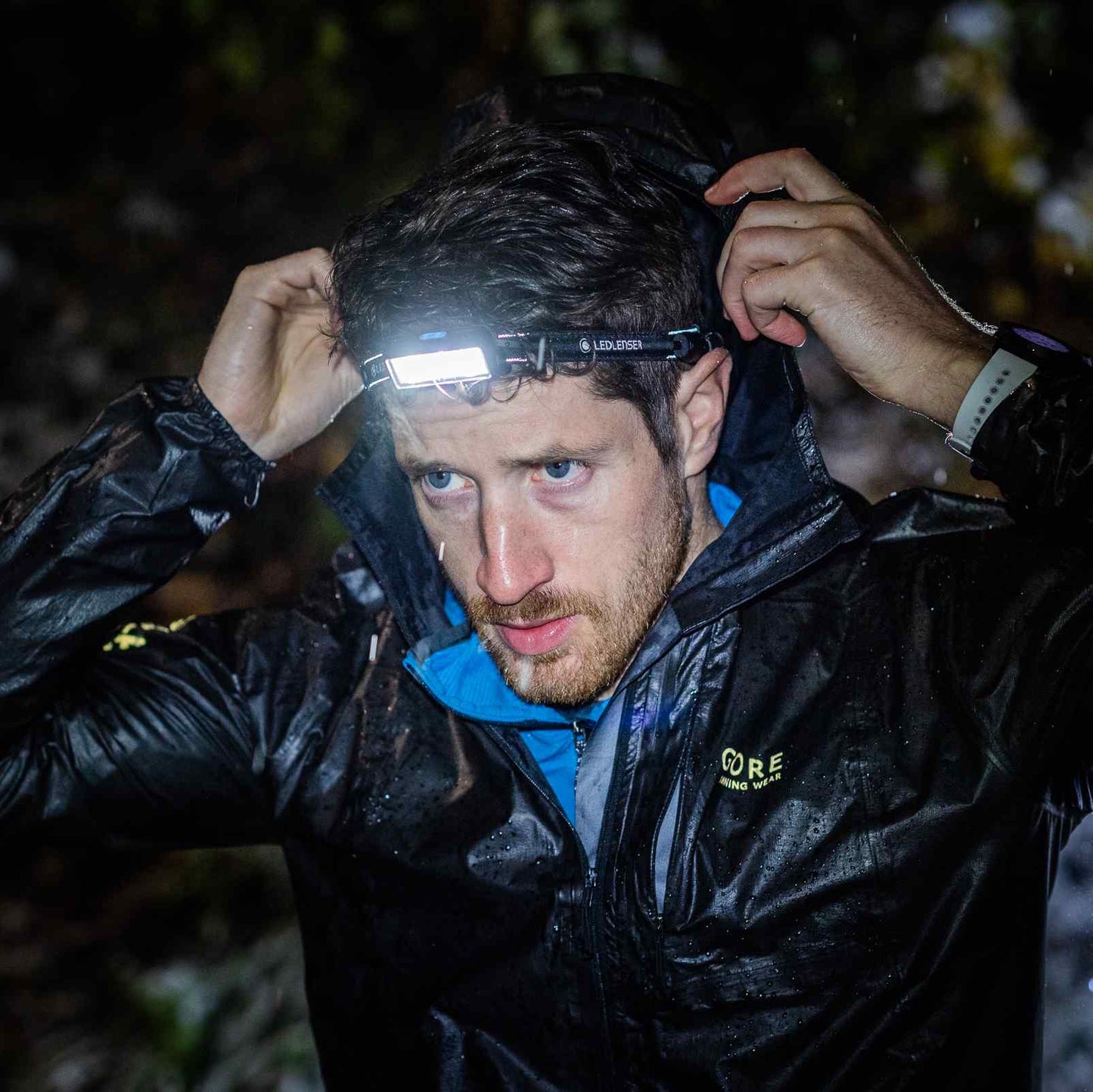 Person wearing a headlamp in a dark outdoor setting