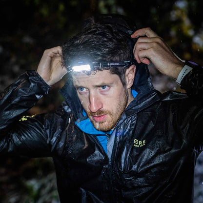 Person wearing a headlamp in a dark outdoor setting
